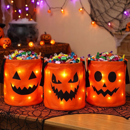 Three orange LED pumpkin candy buckets filled with candy